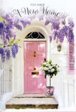 A quiet residential doorway in Stepney has been transformed into a softly spoken celebration, the kind of entrance you might discover on a side street near Stepney Green Station. The door itself is a tender pastel pink, gently glowing as daylight settles across its surface and the nearby whitewashed walls. Overhead, long trails of wisteria drip from above, their clustered blooms in lavender and lilac forming a romantic arch that partially frames the doorway. The blossoms hang in relaxed, tumbling strands, and you can almost imagine the faint rustle of their leaves when a breeze comes up from Commercial Road. To the side, a softly painted shutter adds balance and a touch of rustic charm. On the doorstep, a grey tin florist's bucket has been thoughtfully filled with an abundant arrangement of white and cream roses, their velvety petals unfurling in generous spirals. Fresh greenery peeks out between the blooms, adding a natural rhythm of soft greens to the otherwise pastel palette. Around the bucket's base, a pale pink ribbon is tied in a loose, graceful bow, visually linking the flowers to the door and to the broader mood of tenderness. The whole scene feels like a moment prepared by a caring local florist, perhaps as a surprise new home gift delivered early in the day so it's waiting when the keys finally turn in the lock. Every element-the wisteria, the roses, the ribbon, and the gentle Stepney light-works together to whisper congratulations and offer a peaceful, heartfelt 'welcome home' to the person about to cross this threshold.