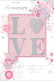 This anniversary card design evokes a gentle celebration of enduring romance, as if chosen from a thoughtful display in a Stepney flower shop on a quiet evening. The colour scheme is a soothing blend of pastel pinks, silvery greys, and soft whites, creating a sense of cherished intimacy. At the centre, the word LOVE is spelled out in softly raised, glitter-dusted letters, with the letter O replaced by a shimmering silver heart. The heart has a textured, slightly faceted look that glints in the light, suggesting the strength and sparkle of a long relationship nurtured over the years in homes around Stepney. Surrounding this focal word, delicate blooms in blush, mauve, and muted ivory appear to unfurl with an almost watercolour softness. Their fine, flowing outlines and gentle shading give the impression of petals just opening, like roses and lisianthus freshly unwrapped from a florist's paper. Slender vines, curling tendrils, and airy sprays weave around the flowers, punctuated by minute flourishes - scattered petals, light swirls, and subtle, near-translucent butterflies - adding motion and a whisper of whimsy, reminiscent of an English spring garden after rain. The background remains a quiet, powdery pink, allowing the floral illustrations and shimmering details to stand out without feeling busy. Text reading On Our Anniversary and I love you today and always appears in understated, elegant script, its flowing strokes echoing the curves of the vines. The composition has the feeling of a keepsake: soft-spoken yet deeply heartfelt, like the accompanying message on anniversary flowers delivered across Stepney to mark the shared journey of two lives intertwined.